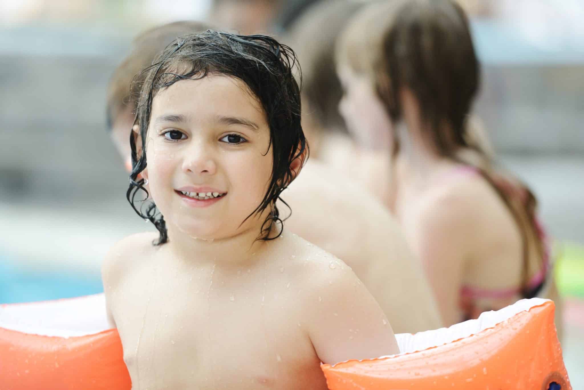 Children enjoying a fun swimming lesson in a backyard pool.